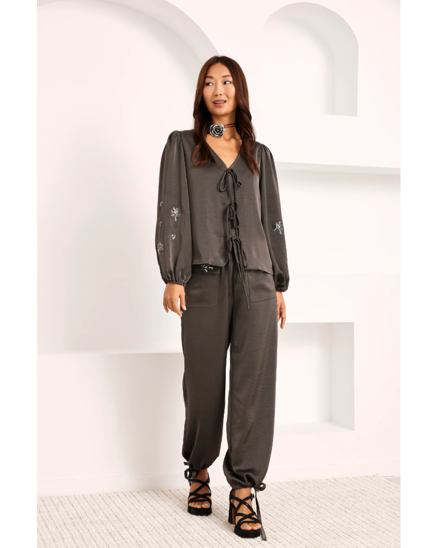 Pantalón liso con aplique pedrería en bolsillo.