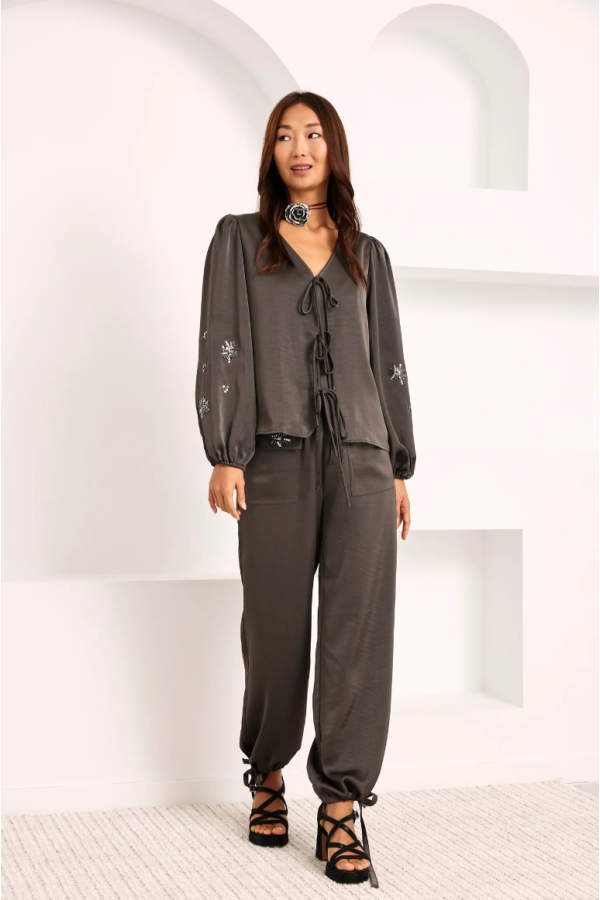 Pantalón liso con aplique pedrería en bolsillo.